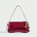 Red handbag with gold accents and cherry decorations on a white background